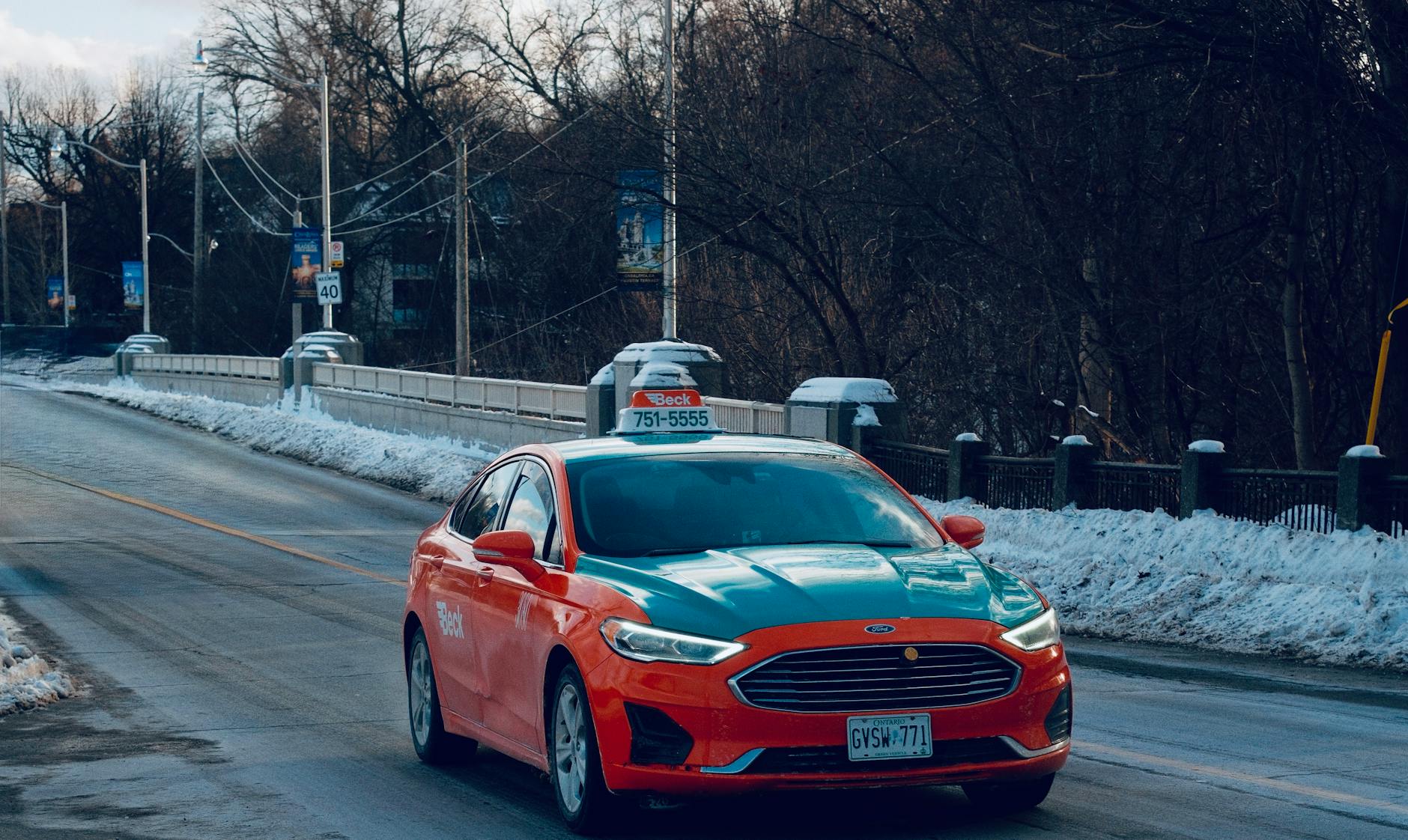 Taksówka jedzie po ośnieżonym moście w zimowym krajobrazie Toronto