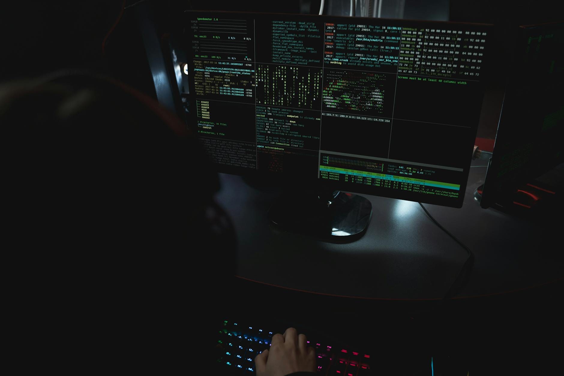 Ciemny pokój z monitorami pełnymi kodu symbolizujący cyberataki