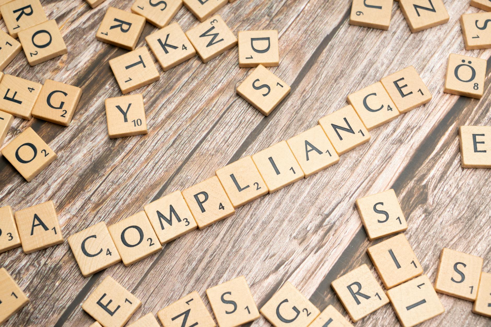 Startup a licencje oprogramowania: jak zbudować legalne środowisko pracy Drewniane kostki z napisem compliance na drewnianym tle