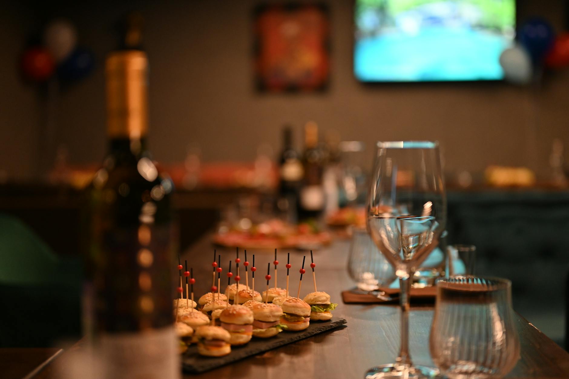 Elegancki stół z miniburgerami, kieliszkami wina i dekoracjami