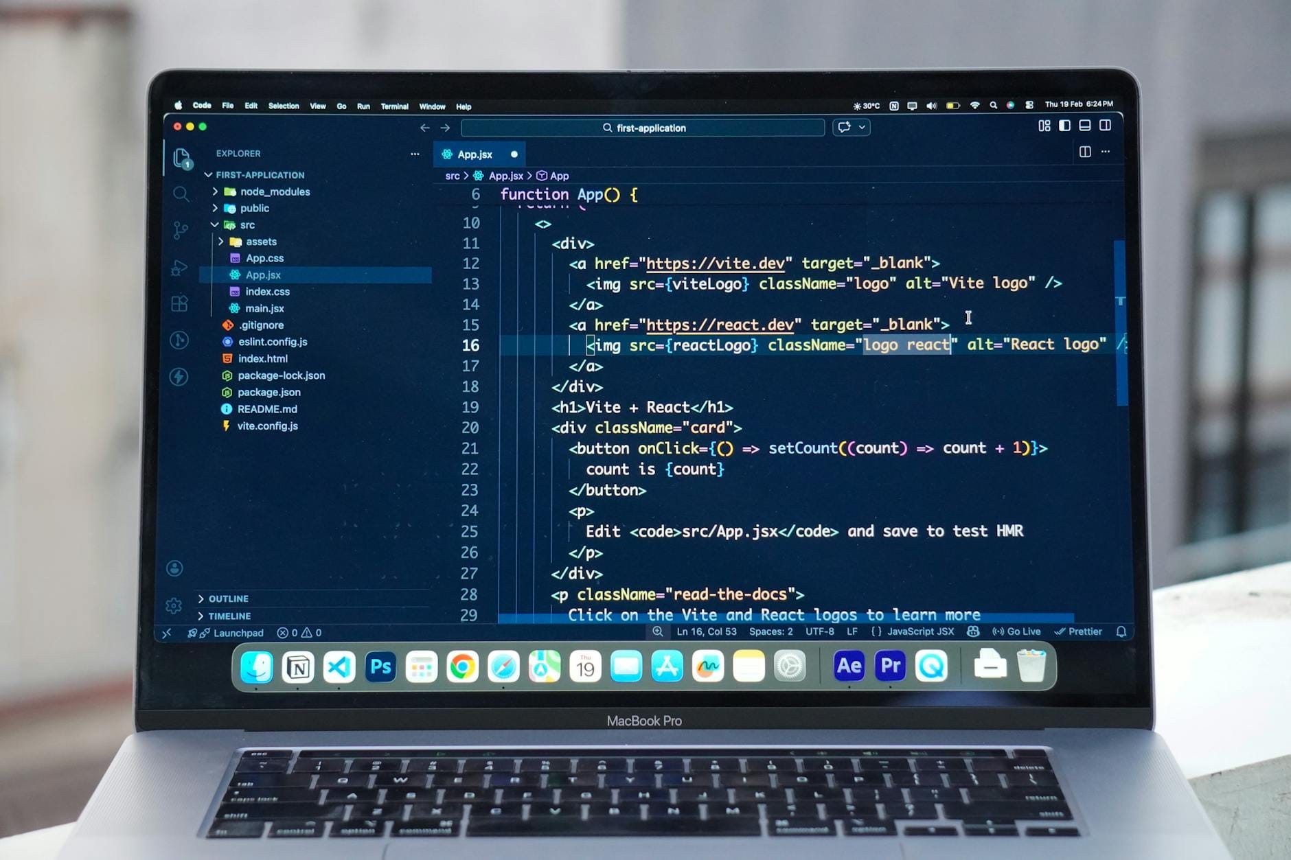 Programista pracuje na MacBooku z edytorem kodu na dachu budynku