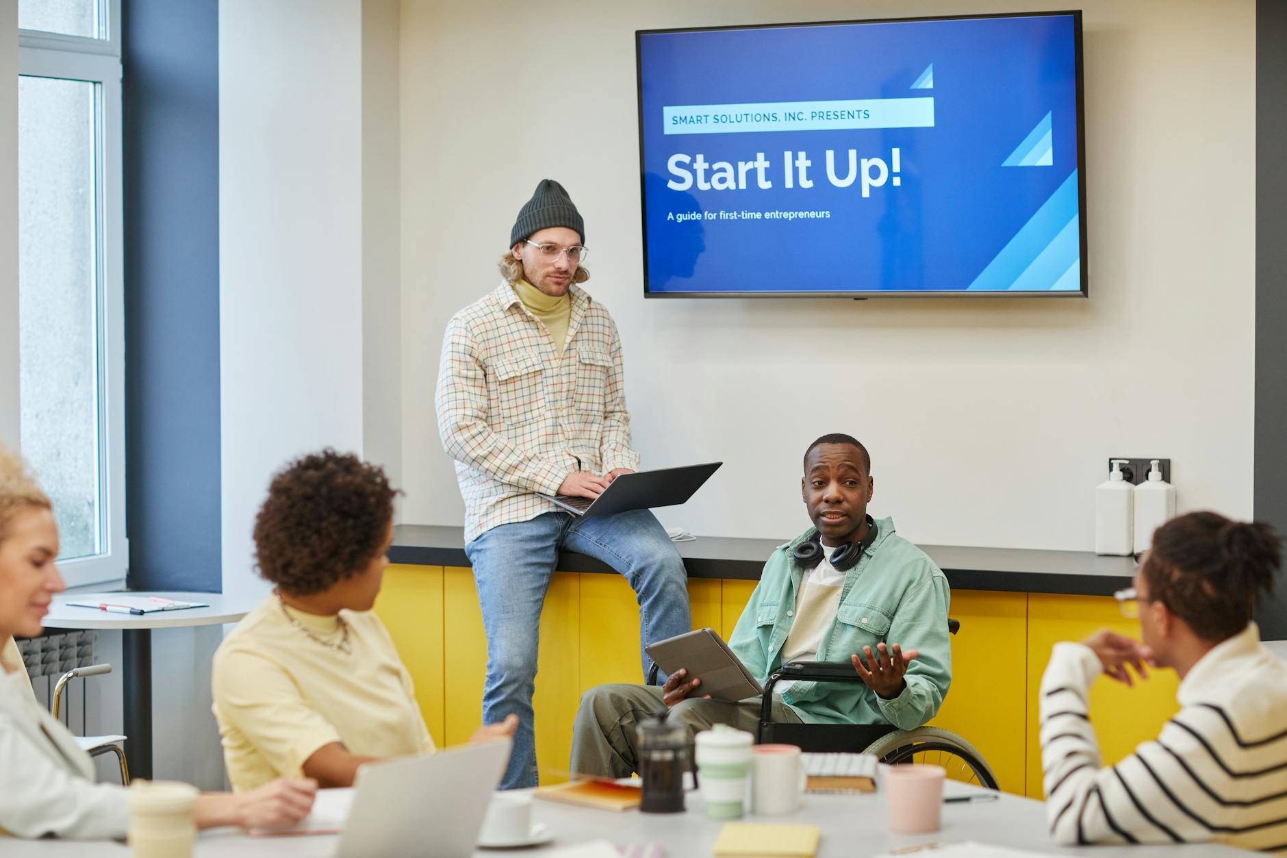 Różnorodny zespół omawia strategię technologicznego startupu w biurze